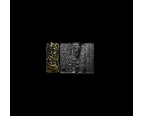 19th-16th century BC. A cylinder seal of black jasper with green inclusions, pierced vertically for suspension; accompanied b