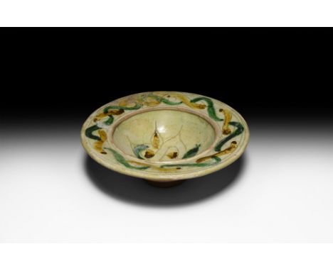 12th-15th century AD. A ceramic sgraffito bowl with hemispherical body, broad flared rim and deep foot; the decorative design