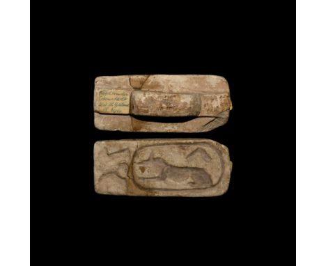 New Kingdom, 1550-1070 BC. A rectangular ceramic stamp seal with pierced handle, intaglio 'cartouche' with crouching jackal, 