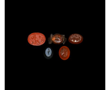 1st century AD and later. A mixed group of five cut and polished gemstones: one carnelian ovoid-shaped stone mounted on a fra