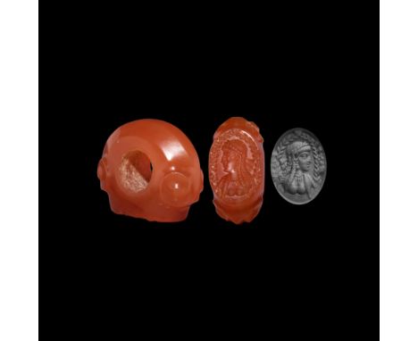 3rd-7th century AD. An annular carnelian seal with scrolled shoulders, intaglio female bust beneath a wreath, hair dressed in