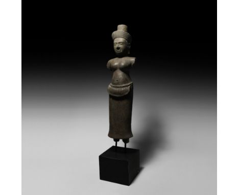 9th-11th century AD. A sandstone carved statue of Lakshmi wearing a pleated sampot with sash tied at the hips; mounted on a c