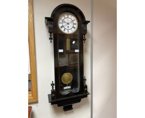 A Vienna regulator time piece, two piece white enamel dial with subsidiary seconds, in an ebonised case with glazed front and