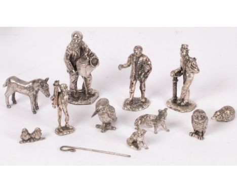 A group of white metal figures, including shepherd, chimney sweep, organ grinder, owl, donkey, etc. CONDITION REPORT: Conditi