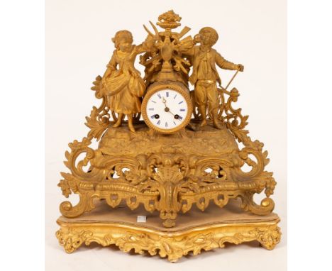 A 19th Century gilt metal eight-day mantel clock with figural surmount, pierced base and scroll feet on a gilt wood base, 39c