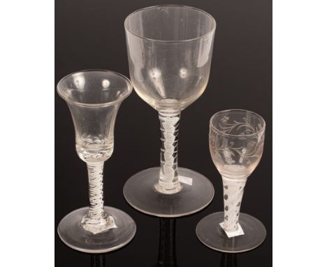 An English 18th Century wine glass with a bell bowl and solid base on a stem with two white spirals, 15.5cm high, a large gob