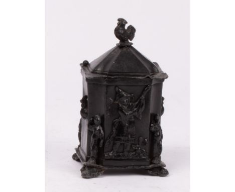 A lead tobacco jar, with cockerel finial, square canted shape, relief figures of musicians on four shaped feet, approximately