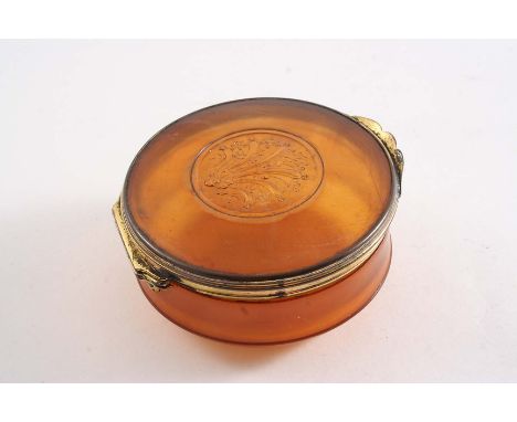AN EARLY 18T CENTURY GILT-METAL MOUNTED BLOND HORN SNUFF BOX circular with a pressed decorative boss in the centre of the cov