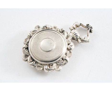 A GEORGE IV PENDANT VINAIGRETTE of shaped circular outline with scroll borders and an engine turned centre on each side, vaca