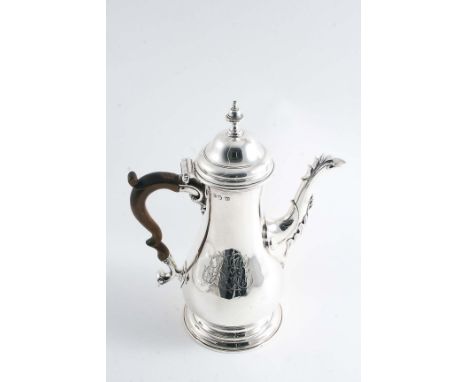 A GEORGE III COFFEE POT of baluster form with a spreading circular foot, a leaf-wrapped spout & a domed cover with a knop fin