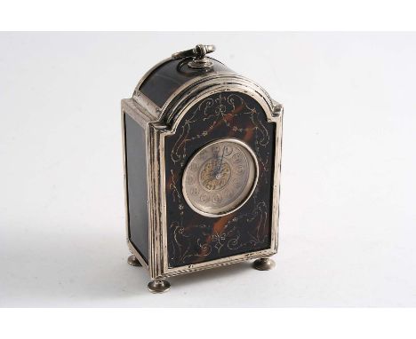 AN EARLY 20TH CENTURY MOUNTED TORTOISESHELL BOUDOIR TIMEPIECE with an arched top, swing finial &amp; pad feet, the front with