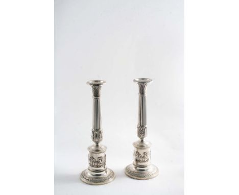 A PAIR OF EARLY 19TH CENTURY GERMAN NEO-CLASSICAL CANDLESTICKS with circular bases, fluted columns and an applied frieze of f