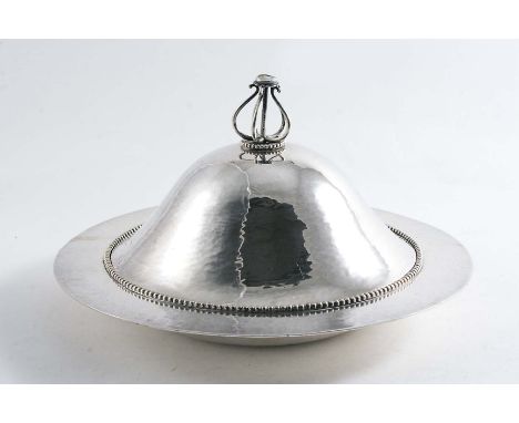 A LATE VICTORIAN ARTS & CRAFTS PLATED DISH & COVER with a hammered finish and a beaded border, the wirework finial set with a