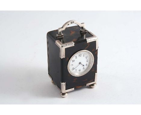 A LATE VICTORIAN MOUNTED TORTOISESHELL CARRIAGE TIMEPIECE with a swing handle, bun feet and a white enamelled dial with black
