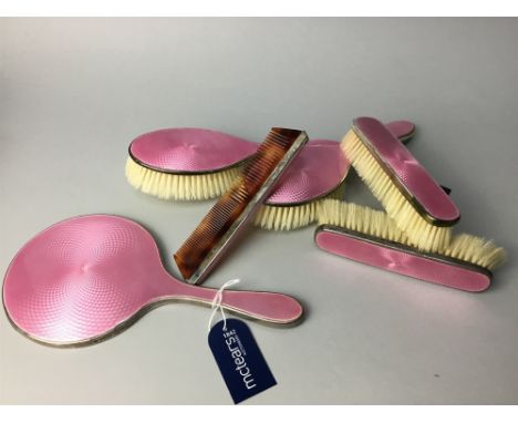 SIX PIECE SILVER AND PINK GUILLOCHE ENAMEL DRESSING TABLE SET, comprising hand mirror, two hair brushes, two clothes brushes 