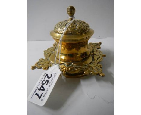 A brass inkwell with ceramic liner.