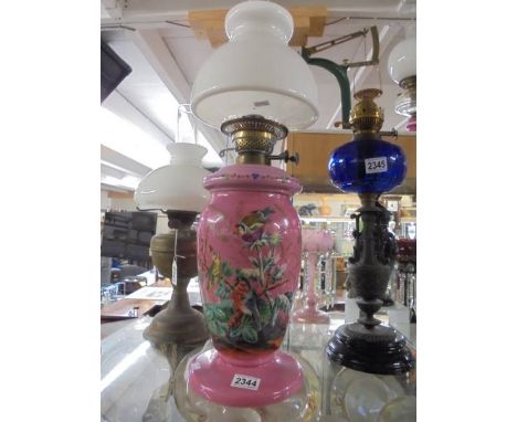 A Victorian overlaid pink glass oil lamp enamel painted with birds. COLLECT ONLY.Burner wick divider is split, no wicks, no o