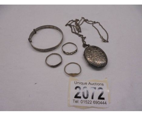 A silver locket on a silver chain, a silver child's bangle and three silver rings, 22 grams.