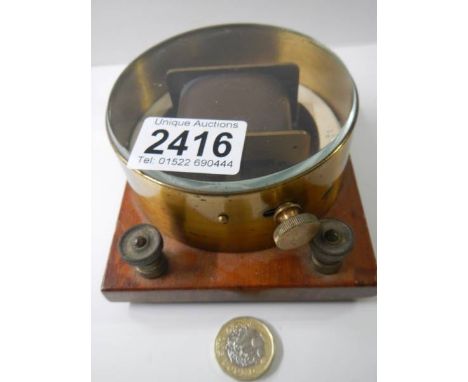 A horizontal differential galvanometer, brass cased on mahogany base, circa 1920.