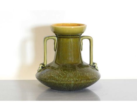 A Linthorpe Pottery twin-handled vase, designed by Dr Christopher Dresser, with a trailing olive glaze, the inside of the rim