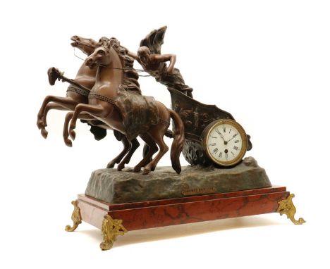 A Victorian mantel clock,the enamel dial with Roman numerals, inset in a spelter chariot group, on a rouge marble base, raise
