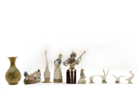 A group of Lladro porcelain,20th century, comprising: a seated musician holding a lute, two figures holding lambs, five geese