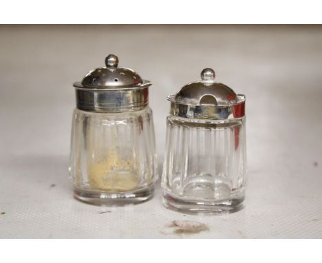 A GLASS SALT AND PEPPER POT WITH HALLMARKED SILVER TOPS