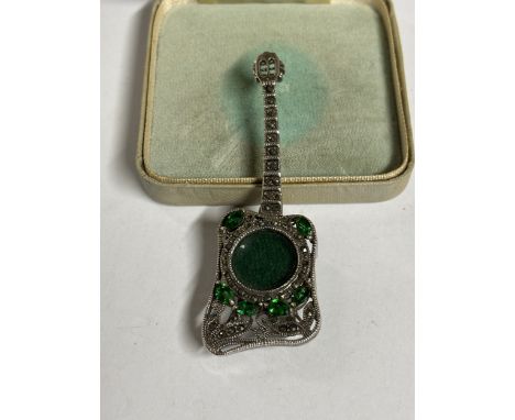 A SILVER AND GREEN STONE GUITAR