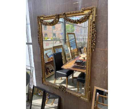 A 19TH CENTURY GILT WALL MIRROR WITH BEVEL EDGE AND DECORATED WITH SWAGS, 47" X 38"