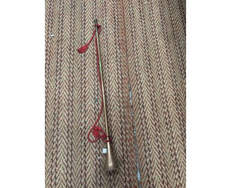A COPPER HUNTING HORN WITH RED SASH