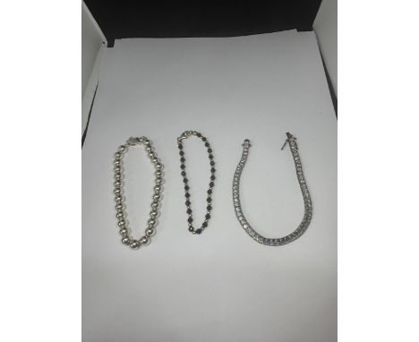 THREE MARKED SILVER BRACELETS TO INCLUDE A BALL DESIGN AND A CLEARSTONE TENNIS STYLE