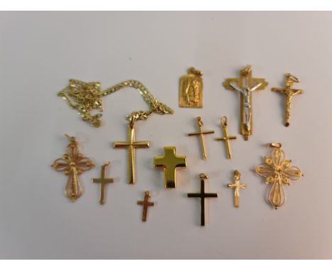 A collection of religious pendants of various sizes and designs, to include ten crosses, one on hallmarked 9ct yellow gold cu