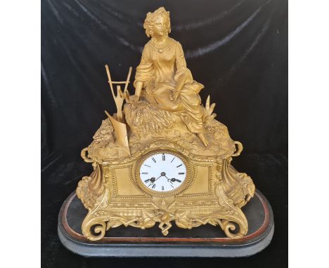 A French gilded clock with figure to top harvest on black wooden base.