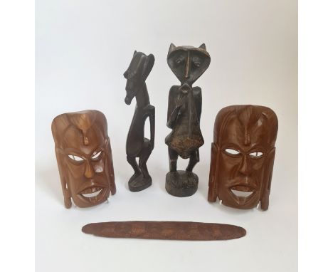 Two African tribal wood figures together with two modern face masks and one Aboriginal message stick.