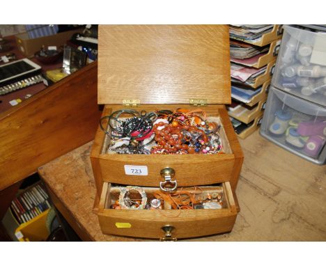 A jewellery box and contents to include a silver gilt bangle; amber coloured beads and various costume jewellery