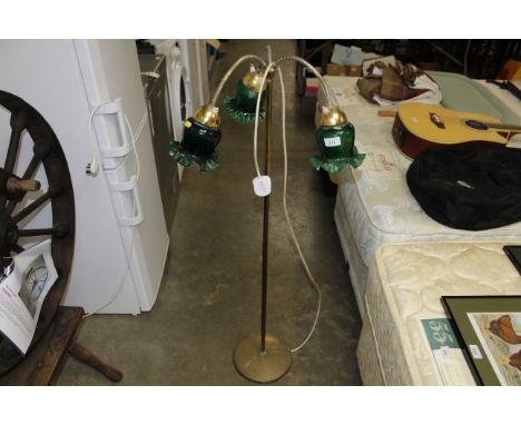 A brass three branch lamp with green glass shades