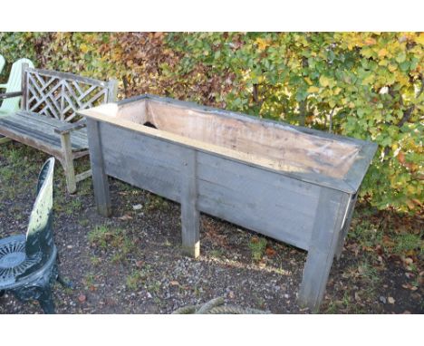 A large wooden garden plant trough