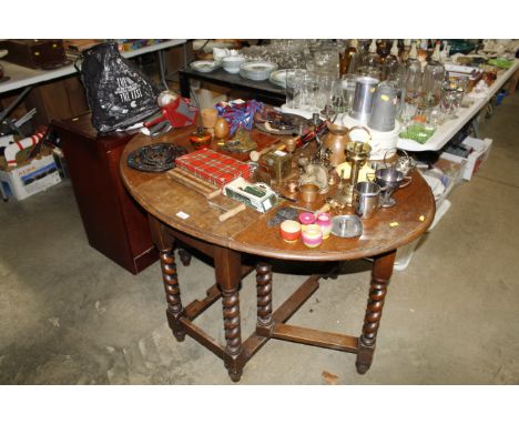An oak gate leg table raised on barley twist supports