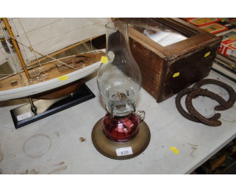 A brass and cranberry glass oil lamp