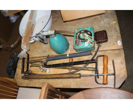 Three stirrup pumps, a BP oil can and advertising tins