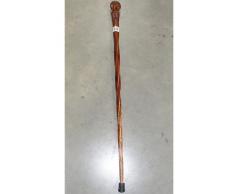 A wooden walking stick with carved kiwi 