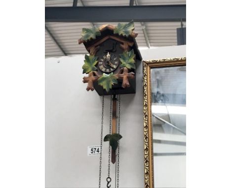 A cuckoo clock with 3 assorted weights