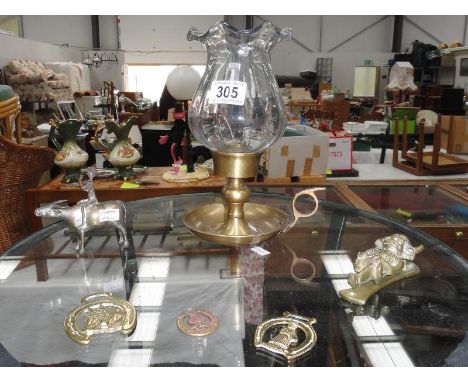 A quantity of brass including Imp door knocker, horse brasses, chamber stick with glass shade etc.