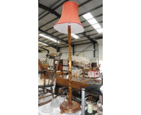 A wooden standard lamp with shade