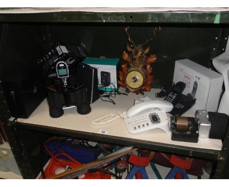 A shelf of micellaneous including telephones & binoculars etc