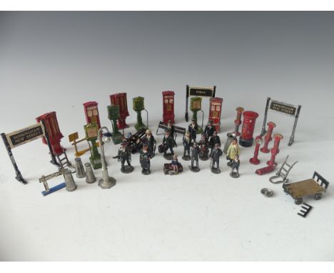 A quantity of vintage '0' gauge lead station figures and accessories, including platform signs, vending machines, scales, sta
