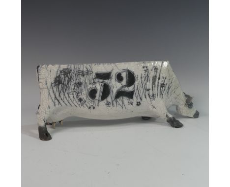 Lawson E. Rudge (b. 1936), a raku fired studio pottery sculpture of an elongated Cow, numbered 52, with sgraffito floral deco
