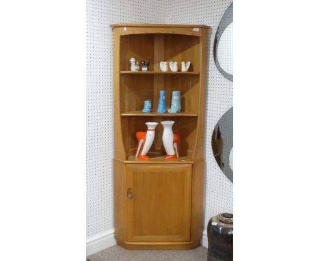 An Ercol blonde 'Windsor' Corner Unit, with open shelving above a cupboard, W 76cm x D 42cm x H 180 cm.