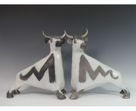 Lawson E. Rudge (b. 1936), a pair of raku fired studio pottery sculptures of Bulls, both with tails missing and damage to hor
