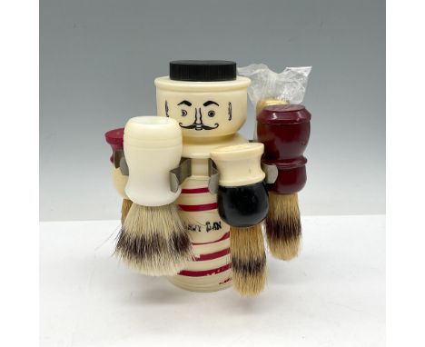 Plastic caddy shaped as barbershop pole that holds 5 shaving brushes with head slit to dispose of used razors. M R Products r